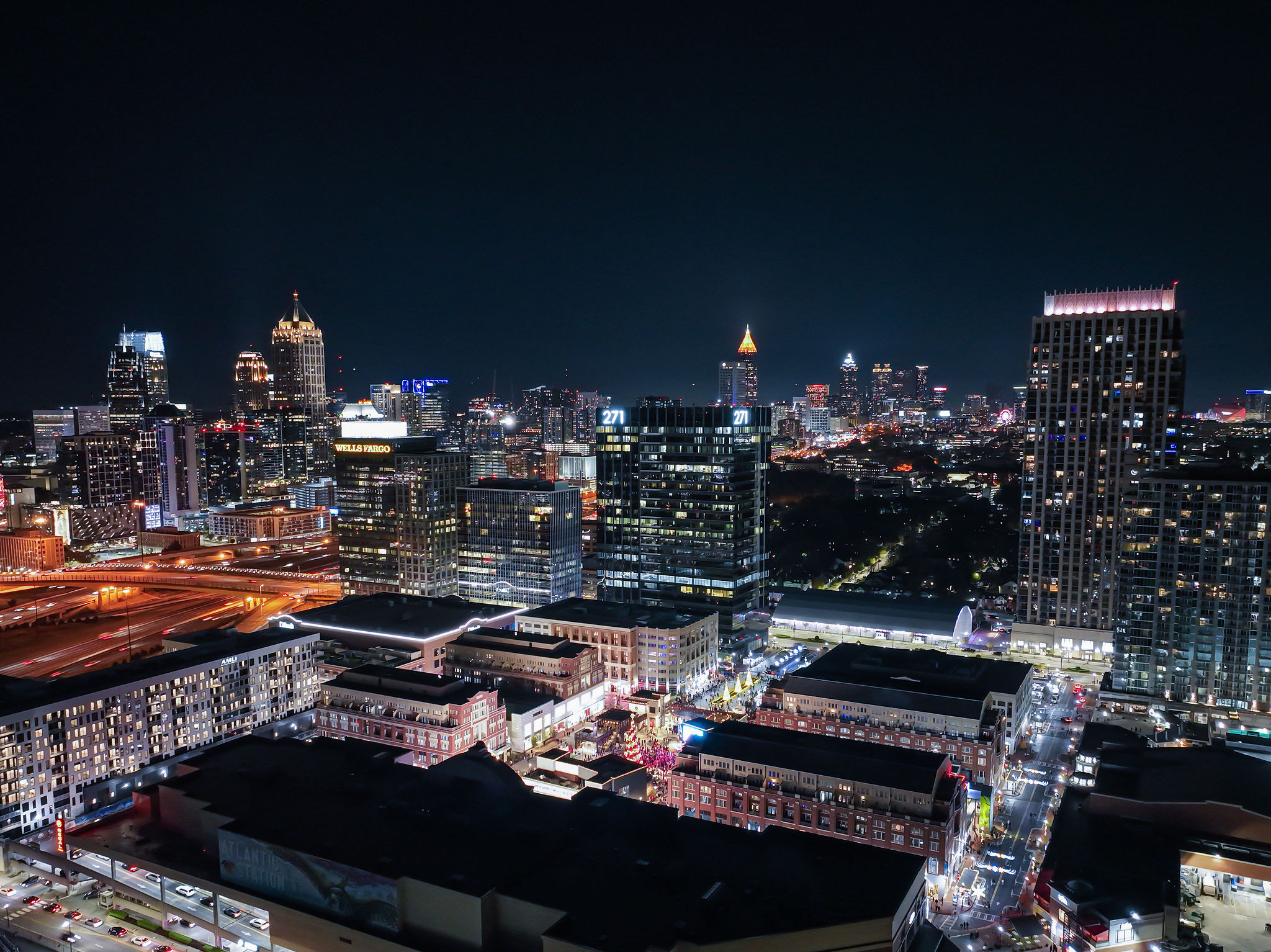 Atlanta skyline at night, featuring numerous illuminated skyscrapers and city buildings.